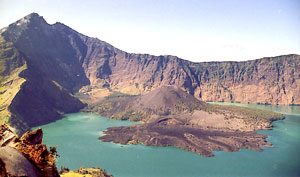 Grandioser Blick vom Kraterrand auf den Segara Anak mit dem kleinen, aktiven Vulkankegel Baru sowie auf den dritthöchsten Gipfel Indonesiens, den Rinjani (links)