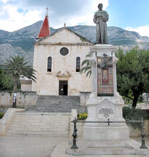 Kacic-Denkmal auf dem gleichnamigen Platz in der Altstadt von Makarska mit Blick auf die St. Markus-Kirche und den Sveti Jure