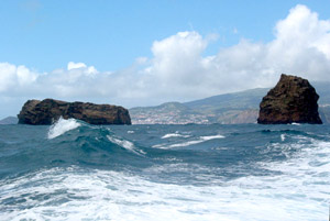 Raue Überfahrt von Faial (im Hintergrund die Hauptstadt Horta) nach Pico: Vor Madalena liegen die Felsinselchen Ilhéu Deitado (die Liegende, links) und Ilhéu em Pé (die Stehende) (Foto: Eichner-Ramm)