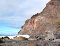 Schwarzer Strand vor steiler Felswand: Playa Inglés